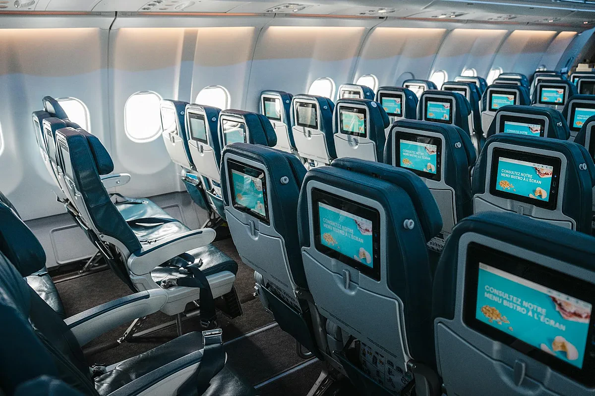 Interior of commercial airplane showing rows of economy class seats