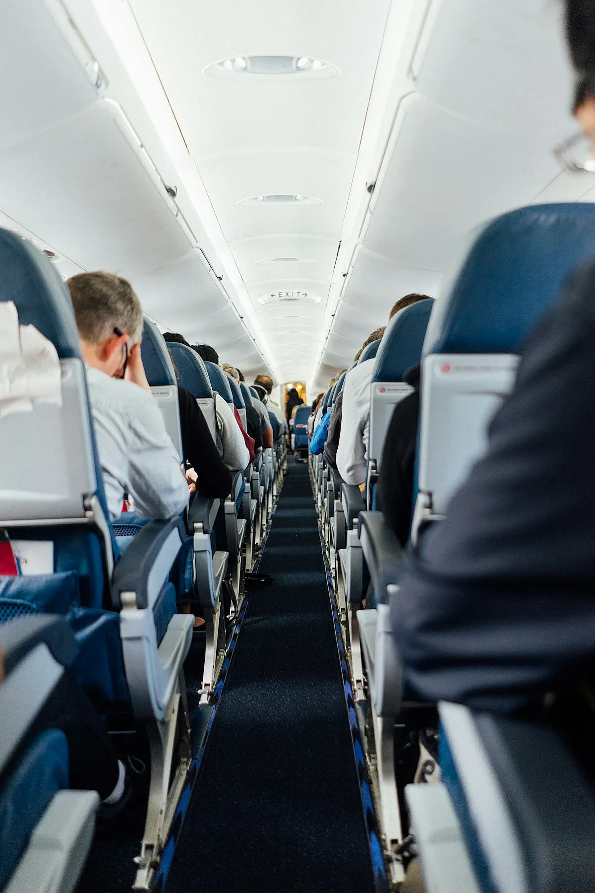 Business class airport lounge with comfortable seating and large windows overlooking runway